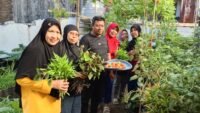 Lurah Karuwisi Hendra bersama jajaran saat memanen tomat dan bayam di kawasan Urban Farming Luxuriyan, Kecamatan Panakkukang, Makassar, Jumat (21/8/2026).