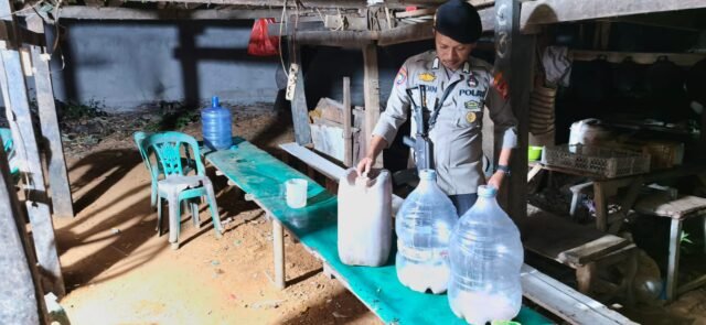 Petugas Polsek Manggala mengamankan sisa minuman keras jenis ballo yang ditemukan di lokasi pesta miras di Kompleks Guru SMAN 10, Jalan Tamangapa Raya V, Makassar, Jumat (18/9) dini hari.