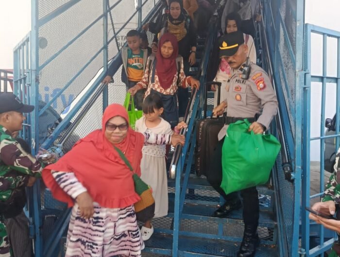 Personel Polsek Soeta bantu penumpang turun dari kapal di Pelabuhan Soekarno Hatta Makassar.